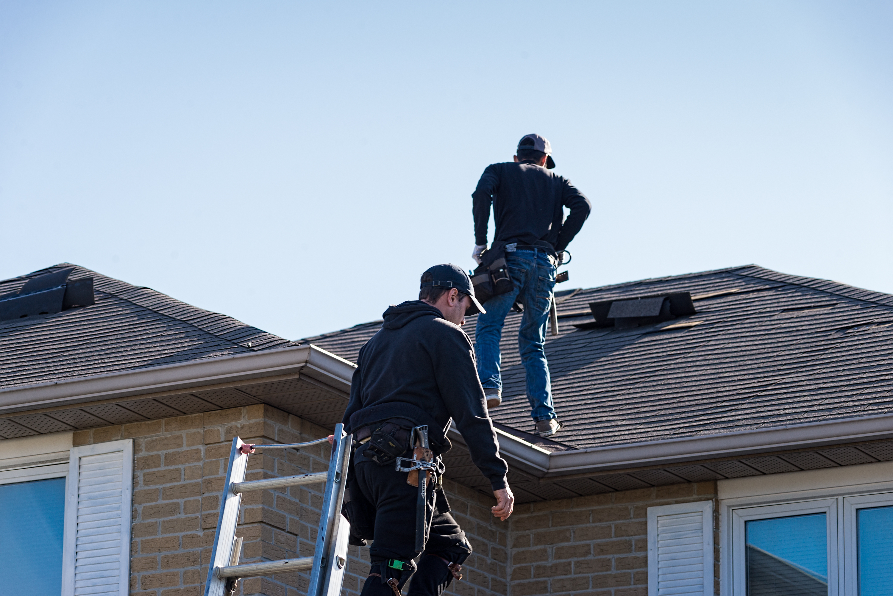 Roofing crew installing shingles on a residential roof
