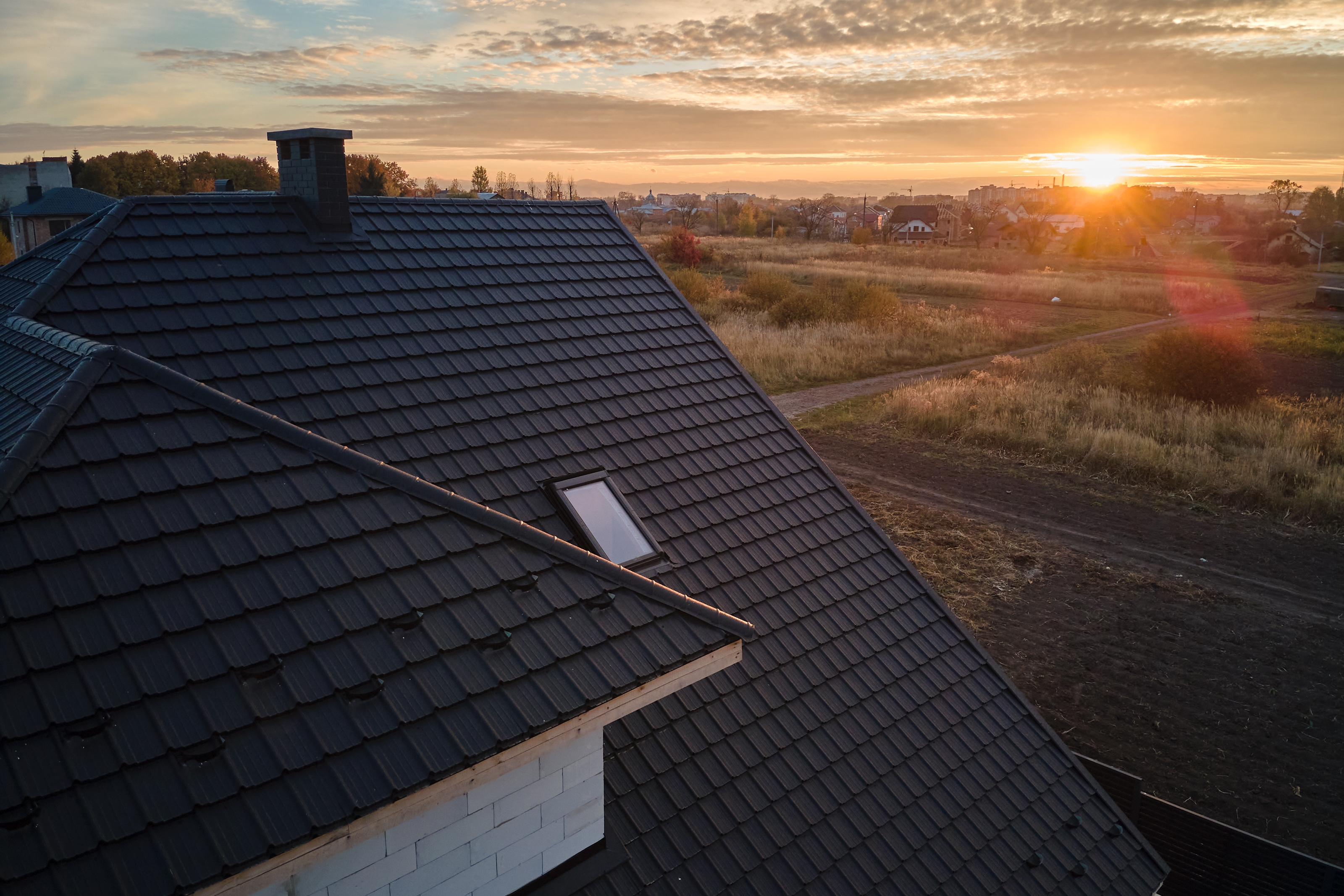 Roof at dusk after a hailstorm — the kind of damage a homeowners insurance claim covers
